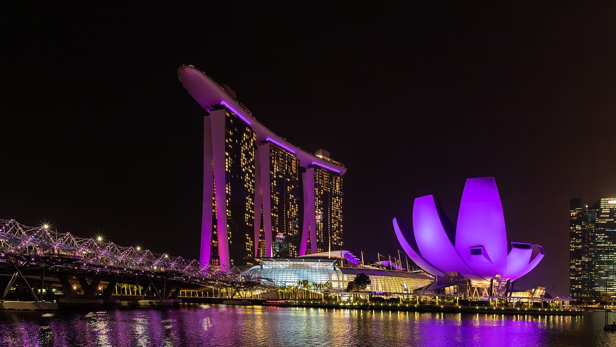 Marina Bay Sands hotel towers and the ArtScience Museum lit in purple at night across Marina Bay, Singapore