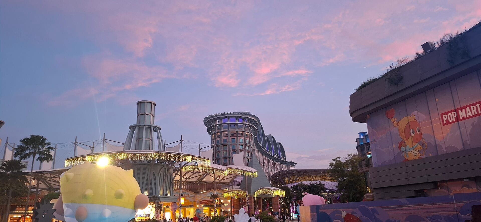The WEAVE precinct at Resorts World Sentosa at dusk, with Hotel Michael in the background.
